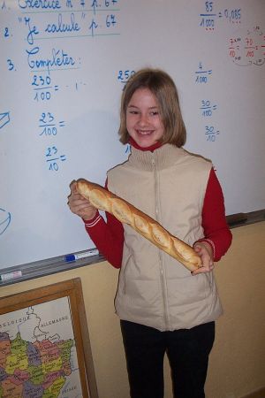 Anna montre une baguette de pain de Rustrel, cuite au feu de bois.